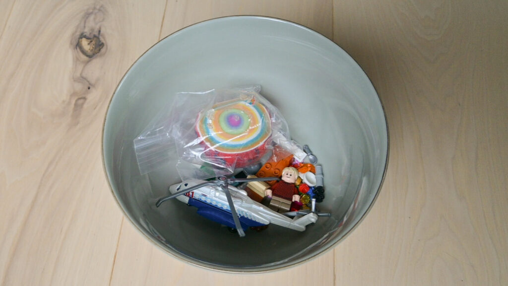 Bowl with a few trinkets including a lego man, a small helicopter and a giant gobstopper makes for several items during a mid-challenge for the 30-day minimalism game