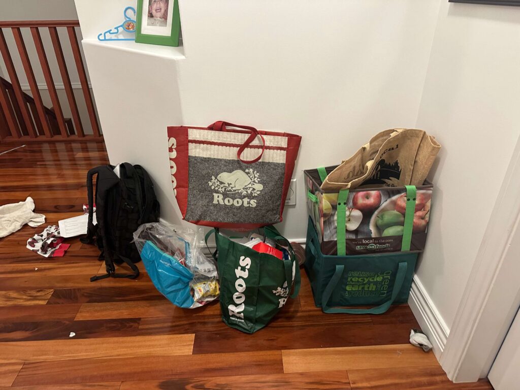 boxes and bags of decluttered things in a hallway