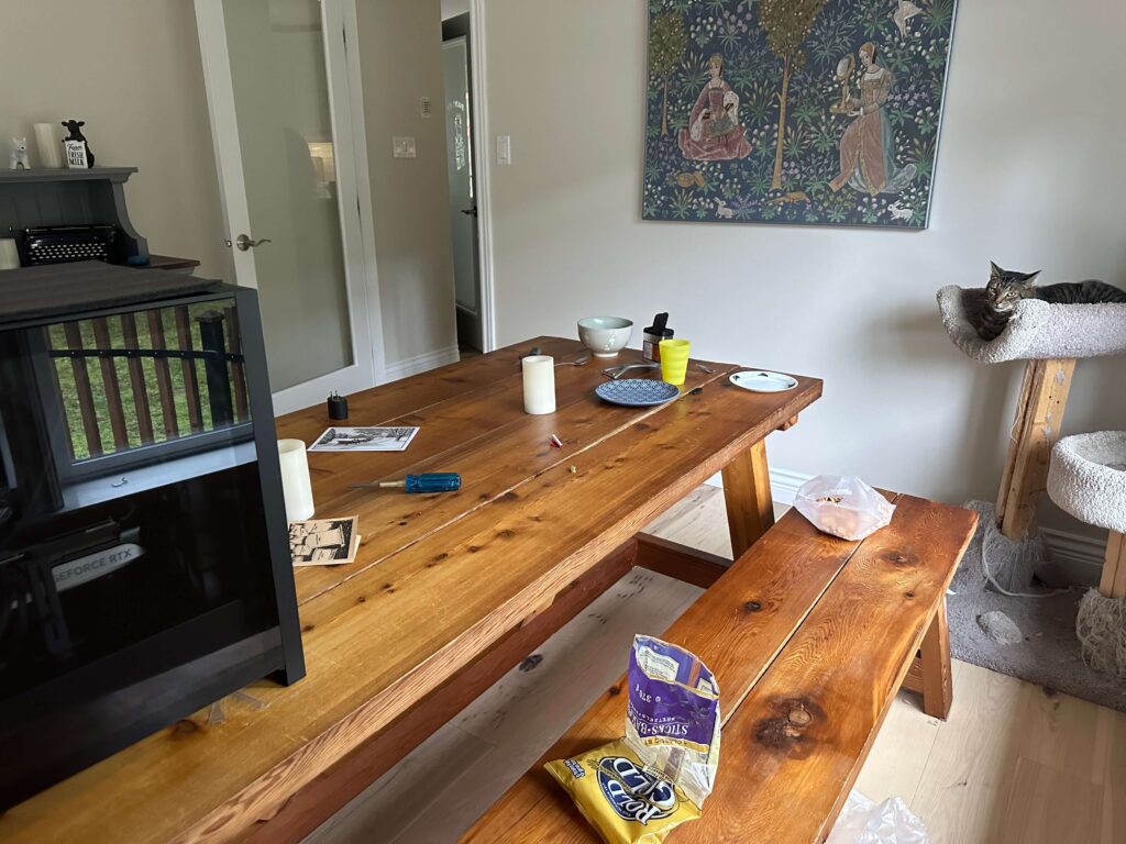 a messy cluttered table with dishes, pretzel bag, and computer parts scattered around can definitely cause anxiety and stress