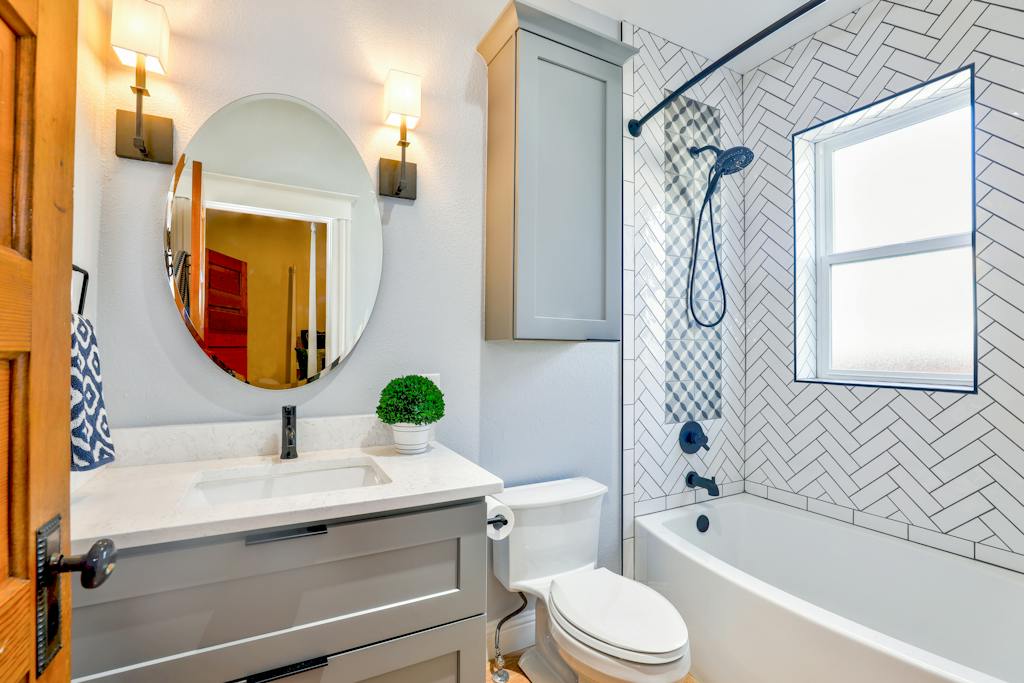 Oval Mirror Near Toilet Bowl. Organize linens in the bathroom vanity