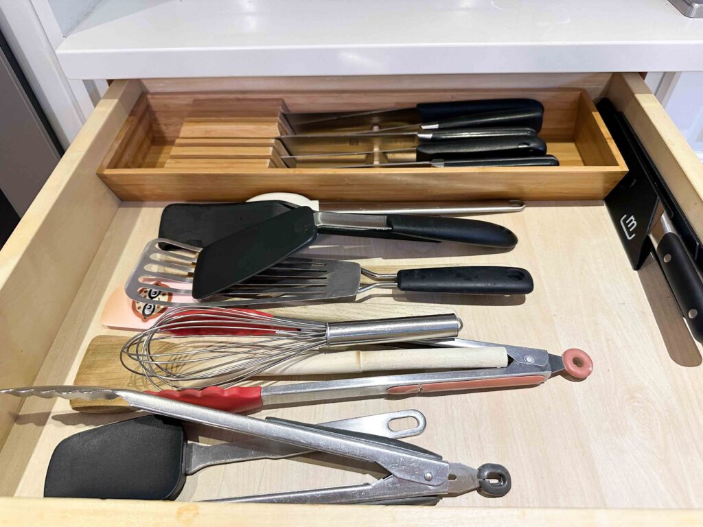 utensils in a drawer including knives tongs for kitchen organization and storage