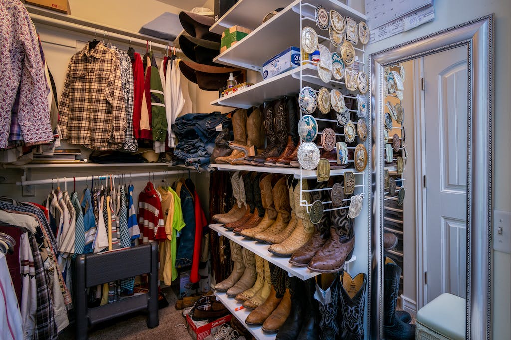 Assorted Clothes and Boots Inside a Closet Room. managing closet smell