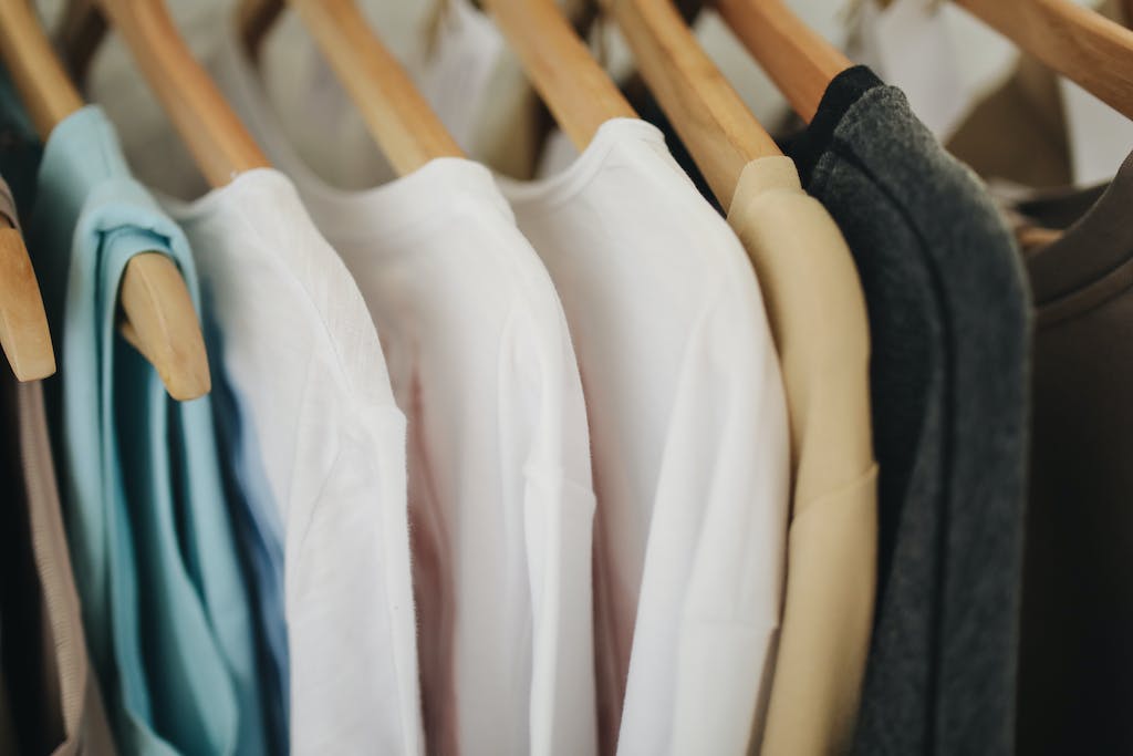 White Long Sleeves Shirts on Brown Wooden Clothes Hanger combined as a minimalist fashion capsule wardrobe