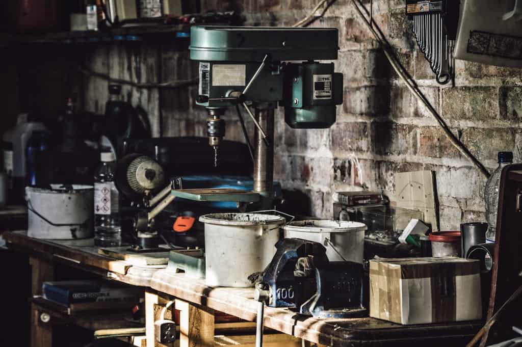 A detailed view of a cluttered workshop with a focus on a drill press and various tools. where to start decluttering in the new year