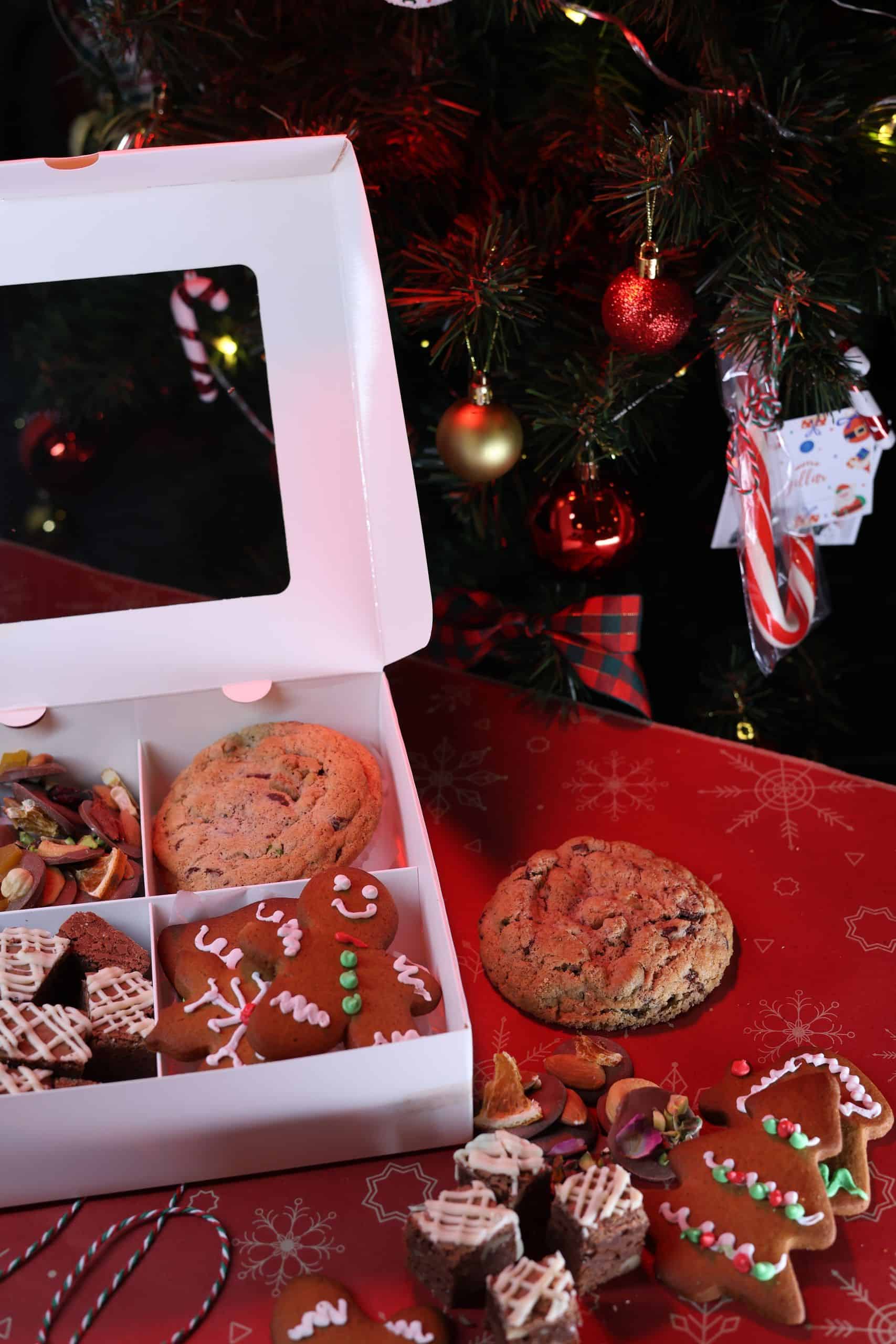 Assorted holiday cookies and treats under a beautifully decorated Christmas tree.