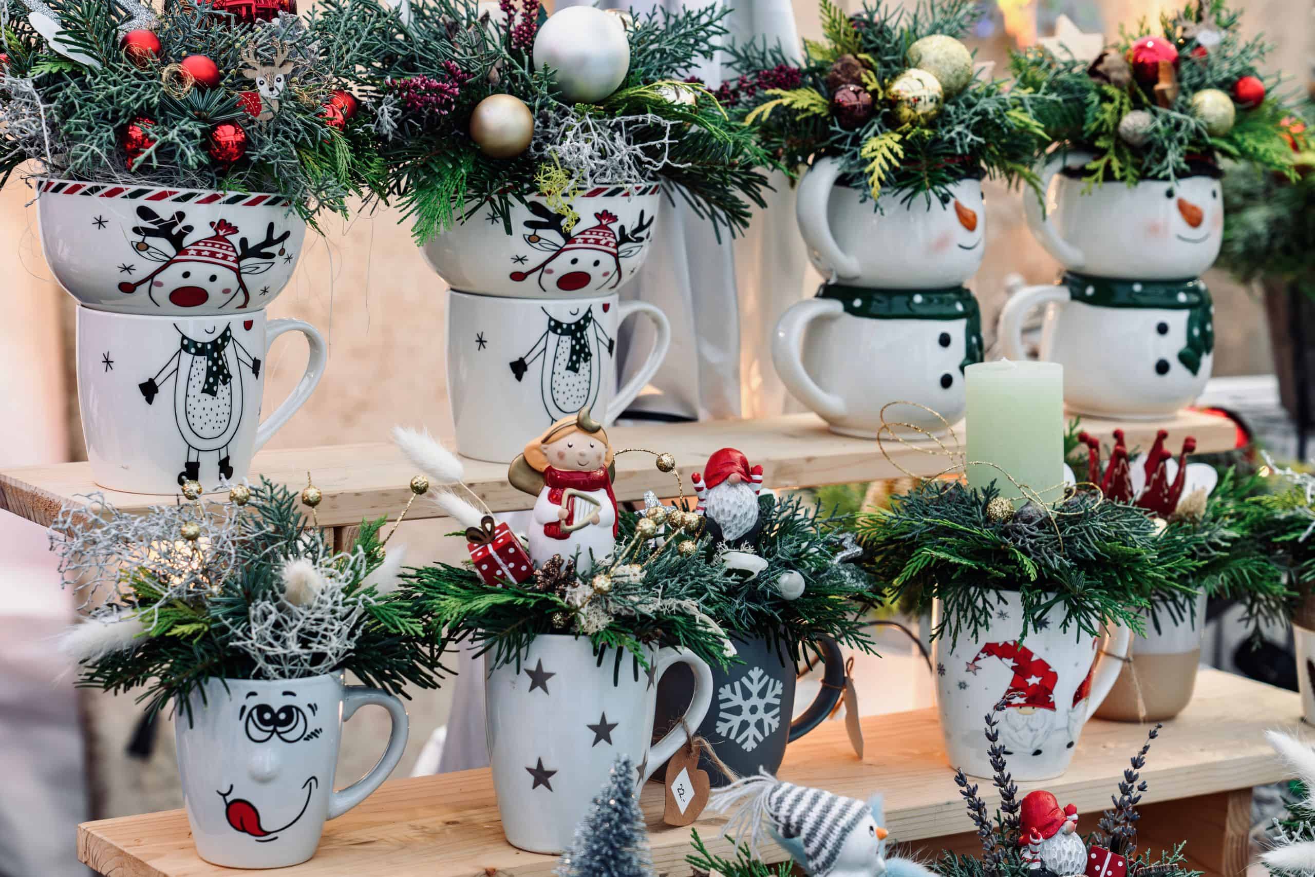 Christmas-themed mugs decorated with evergreen branches and ornaments.