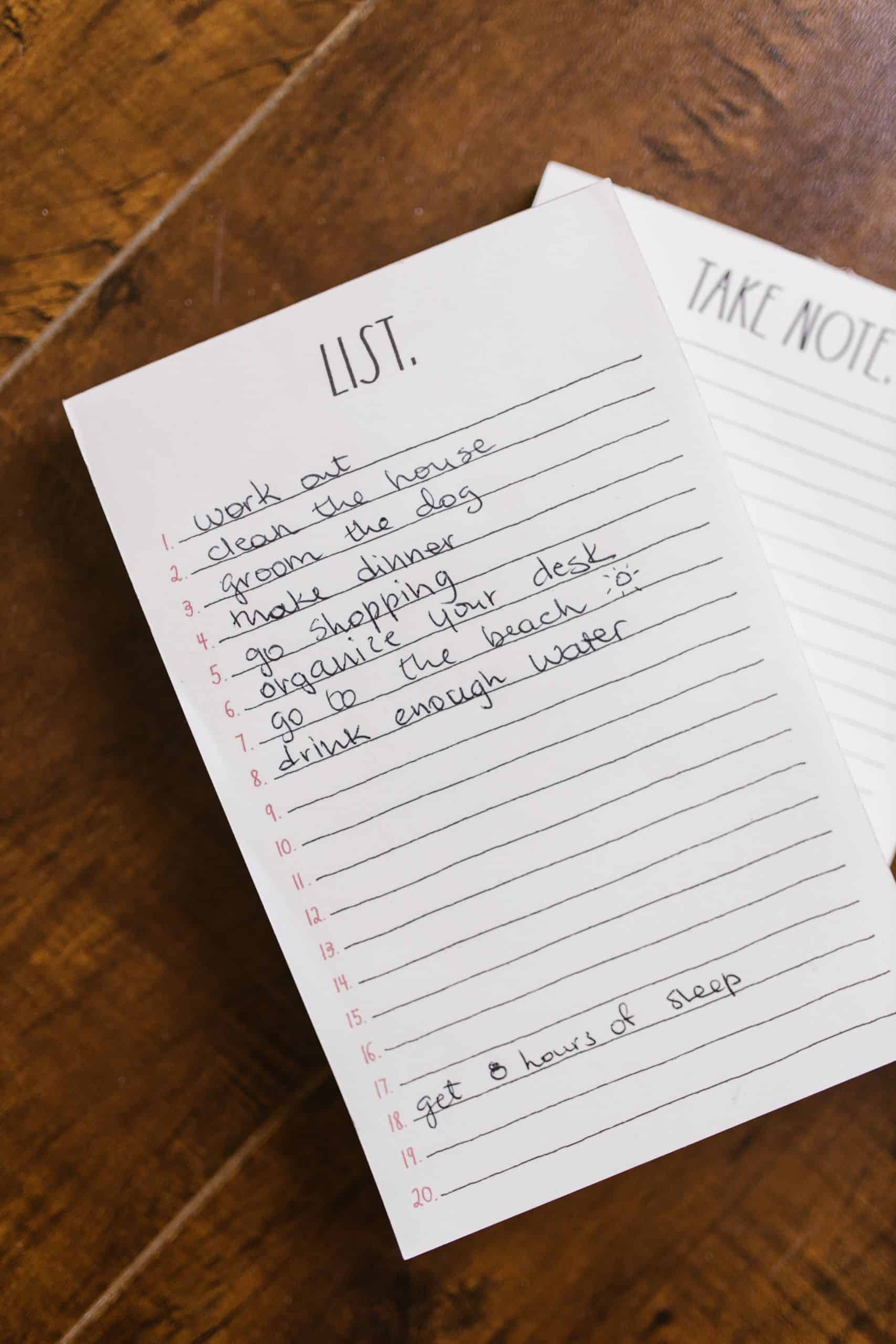 Close-up of a handwritten to-do list on a wooden table for an organized day.